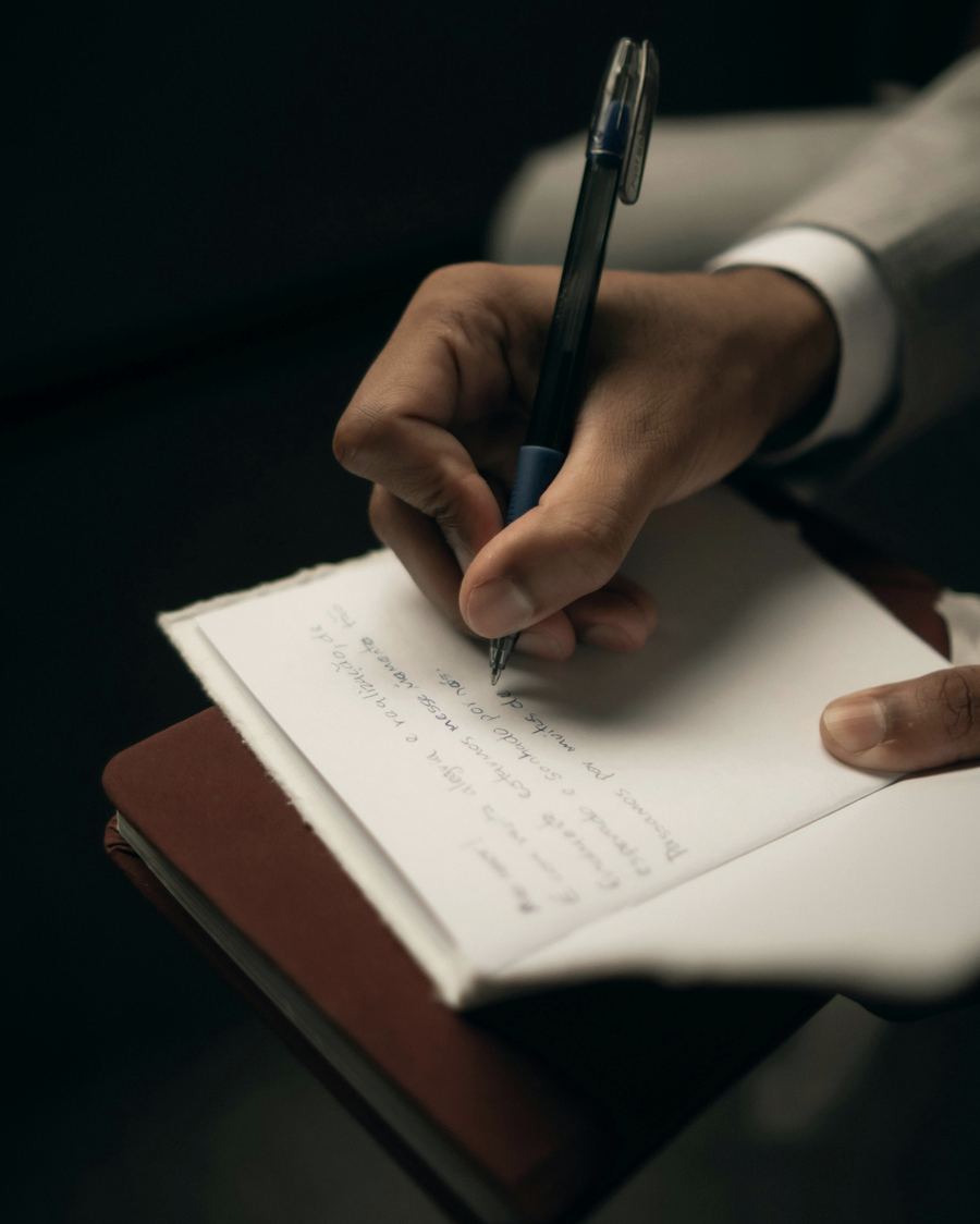 A hand writing in a notebook